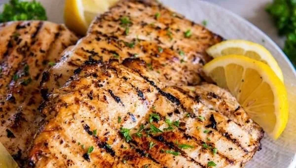 Delicious grilled chicken breast served with fresh herbs and spices.