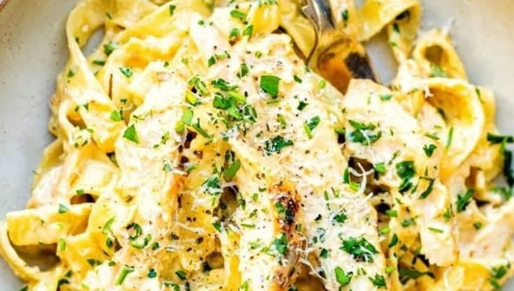 Creamy chicken pasta dish garnished with herbs