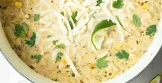 Bowls of creamy white chicken chili with toppings and fresh herbs