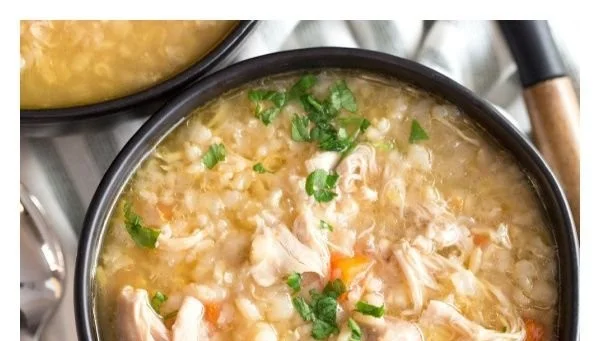 Crock Pot Chicken Rice Soup in a bowl with fresh herbs and vegetables