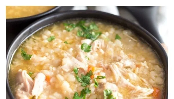 Delicious Crock Pot Chicken Rice Soup in a bowl with fresh herbs