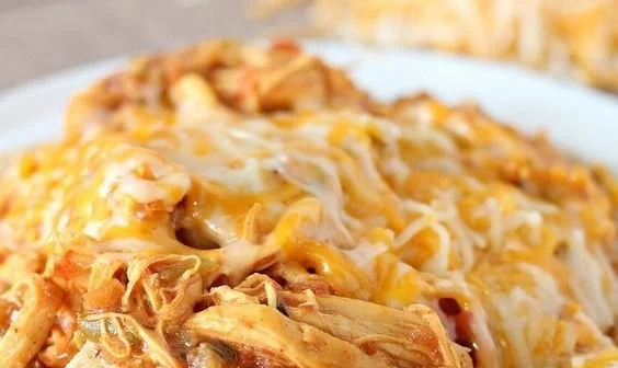 Crockpot Taco Chicken Nachos topped with cheese, jalapenos, and sour cream.