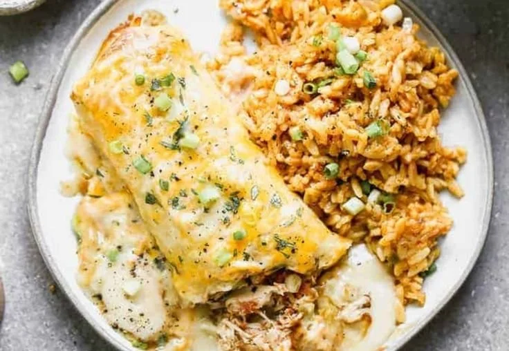 Delicious smothered chicken burritos topped with savory sauce and cheese