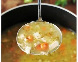 Bowl of rotisserie chicken soup with vegetables and herbs