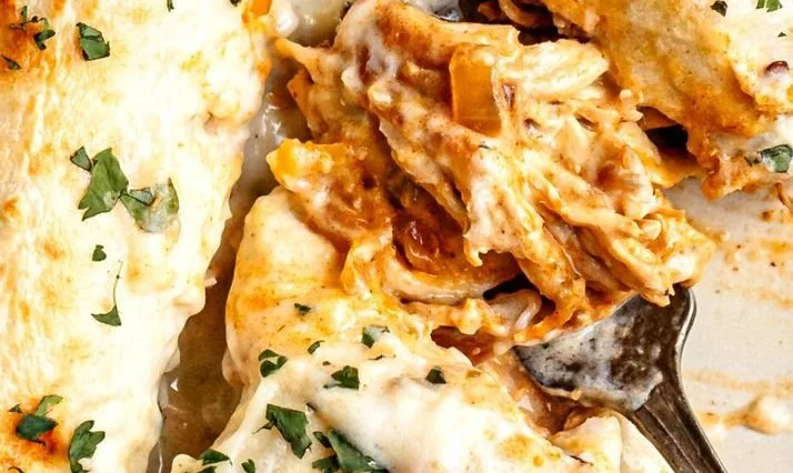 Shredded chicken enchiladas smothered in cheesy sour cream sauce.