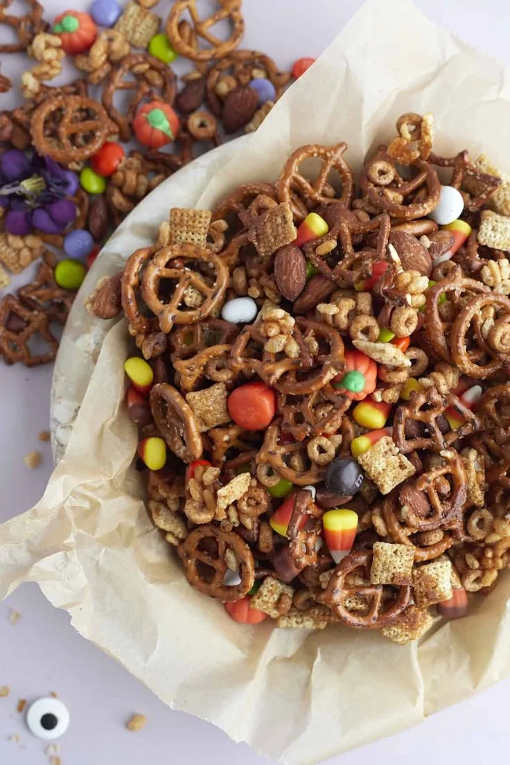 Colorful Halloween snack mix with candies, pretzels, and pumpkin seeds.
