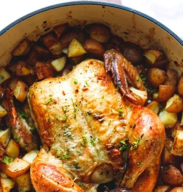 Whole roasted chicken with potatoes, perfectly seasoned and golden brown